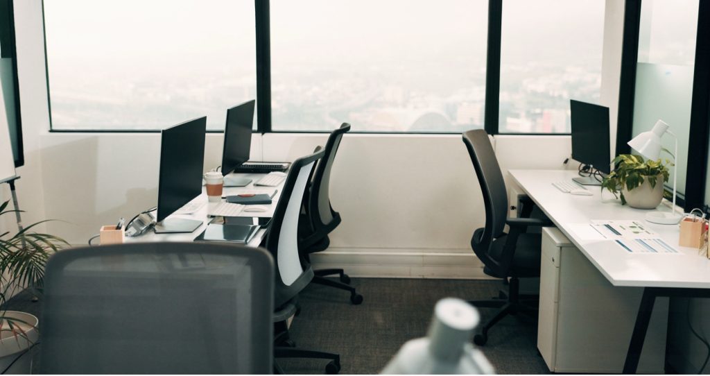 Small shared office workspace with multiple desks and under-desk storage units